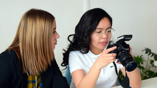 Dos jóvenes emprendedoras tomándole fotos a un producto que han desarrollado