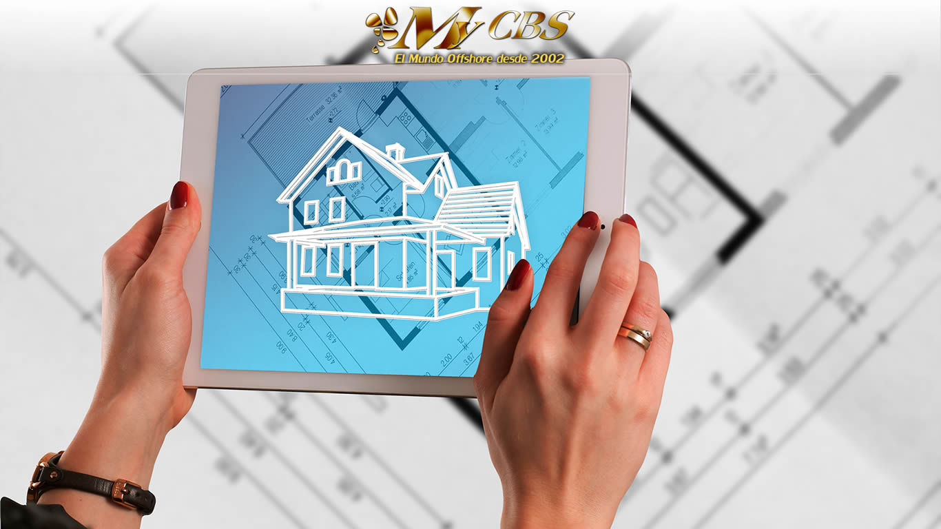 Sigue nuestras recomendaciones finales para lograr el éxito en tu inversión internacional inmobiliaria Mujer observando en una tablet una casa cuyos planos se ven detrás