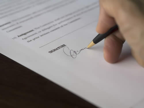 imagen de perona firmando un documento
